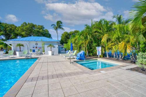 a swimming pool with palm trees and a house at Bright 2BR Condo with Breathtaking Ocean View in Tavernier