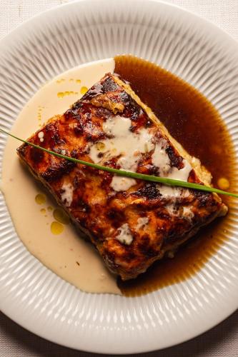 a white plate with a piece of meat with sauce at Bourbon Resort Atibaia in Atibaia