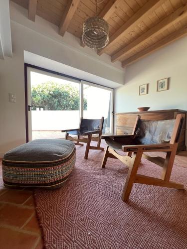 a living room with a large ottoman and a large window at Monte da Aferrada - CASAS DA VILA in Alpalhão