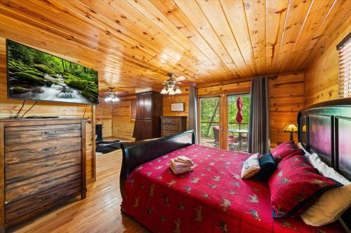 a bedroom with a red bed in a wooden room at Tequila Moon in Sevierville