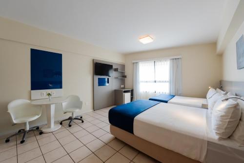 a hotel room with a large bed and a desk at Bourbon Hotel Fortaleza in Fortaleza