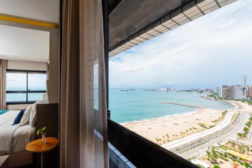 a room with a view of the beach from a hotel room at Bourbon Hotel Fortaleza in Fortaleza