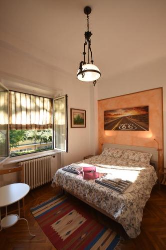 a bedroom with a bed and a table and windows at Invilla B&B in Varese