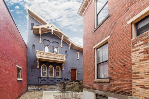 a blue house in the middle of some brick buildings at MONOPOLY - Prime-Location - Walkable - Sleeps 6 in Pittsburgh