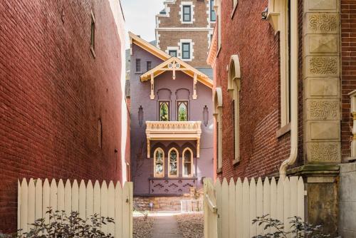 a white fence in front of a pink house at MONOPOLY - Prime-Location - Walkable - Sleeps 6 in Pittsburgh