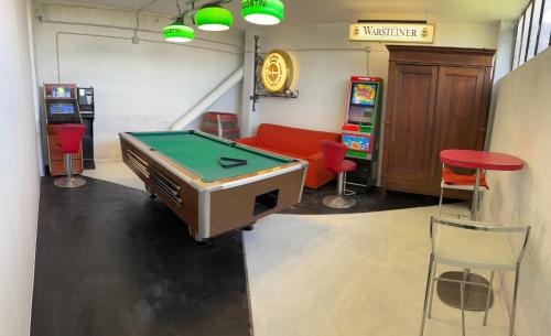 a room with a pool table and two arcade machines at La casa di Cate & Adry in Envie