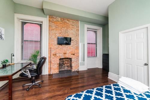 an office with a desk and a brick fireplace at Business Suite - Walkable Entertainment in Pittsburgh
