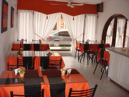 a restaurant with tables and chairs in a room at Hotel Aldea Marina in Villa Gesell