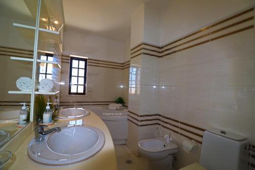 Un baño con dos lavabos y un inodoro. en Quinta do Sol, en Armação de Pêra