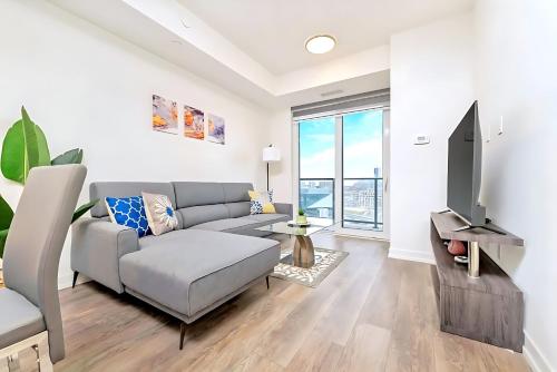 a living room with a couch and a tv at Luxurious 1BR Condo - Stunning City Views in Kitchener