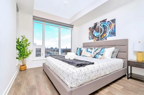 a bedroom with a large bed and a window at Luxurious 1BR Condo - Stunning City Views in Kitchener