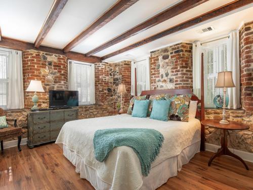 a bedroom with a bed and a brick wall at Habersham 1 in Savannah