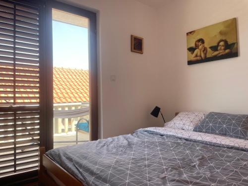 a bedroom with a bed and a view of a balcony at Pier Apartments in Krašići
