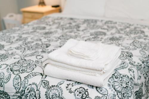 a pile of towels sitting on top of a bed at Modern Chic Suite - Amazing Location - GroupStay in Pittsburgh