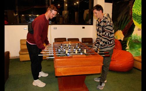 two men are playing with a giant chess at Magic Packer Hostel in Cusco