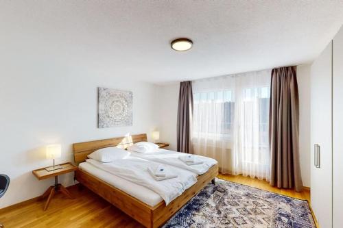 苏黎世Fantastic Penthouse near Lake - Mainau 14的一间卧室，里面有一张床和一扇大窗户。