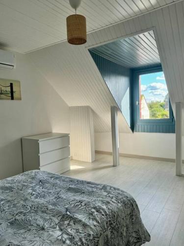 une chambre avec un lit et une grande fenêtre dans l'établissement Les Acacias - Maison de campagne, à Saint-Sulpice