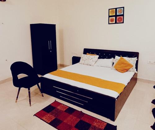a bedroom with a bed and a chair in it at Five BHK Abode in Golf City Lucknow in Nalmatha