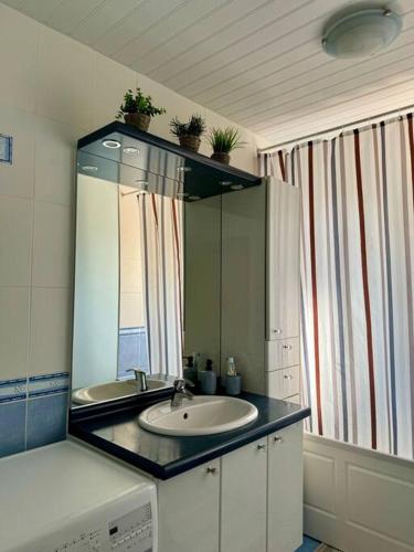 une salle de bain avec un lavabo et un miroir dans l'établissement Les Acacias - Maison de campagne, à Saint-Sulpice