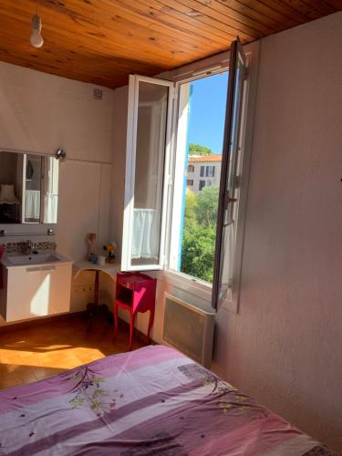 a bedroom with a bed and a large window at T2 cœur de ville La Londe-Les-Maures in La Londe-les-Maures