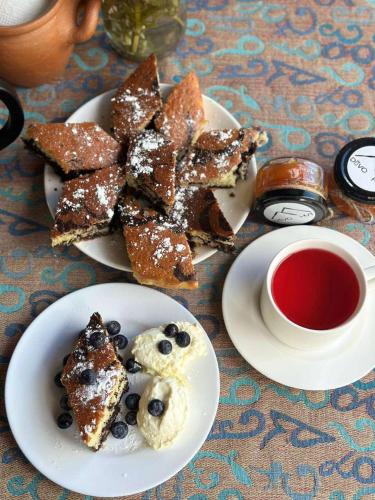 a plate of food with pancakes and a cup of tea at Guesthouse Divo Hut in Ushguli