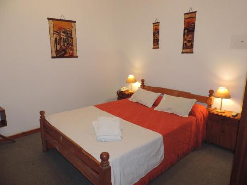 Un dormitorio con una cama con dos toallas encima. en Hotel Aldea Marina, en Villa Gesell