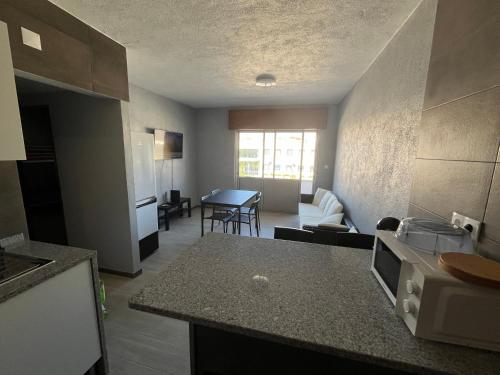 a kitchen and a living room with a table at Sun House - Apartamento in Belas