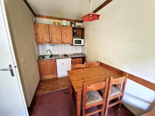 une petite cuisine avec une table et des chaises en bois dans l'établissement Chalets Du Thabor - 2 pièces 4 personnes idéalement situé MAE-2953, à Modane
