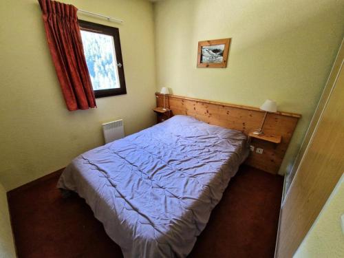 - une petite chambre avec un lit bleu et une fenêtre dans l'établissement Chalets Du Thabor - 2 pièces 4 personnes idéalement situé MAE-2953, à Modane