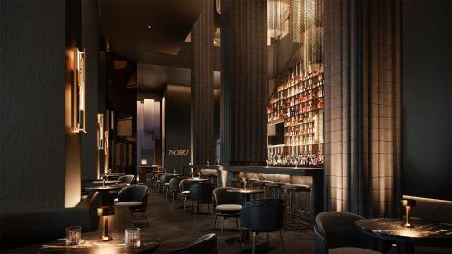 a restaurant with tables and chairs and a bar at Nobu Hotel Toronto in Toronto