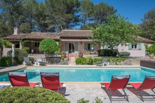une maison avec une piscine et des chaises dans l'établissement Mas de Charles, à Lorgues