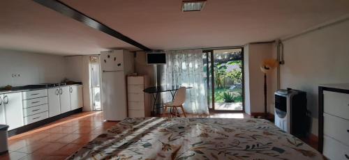 ein Schlafzimmer mit Bett und eine Küche mit Fenster in der Unterkunft Habitación completa e independiente in Creixell