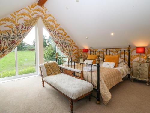 a bedroom with a bed and a large window at Nant-yr-Rhedyn in Benllech