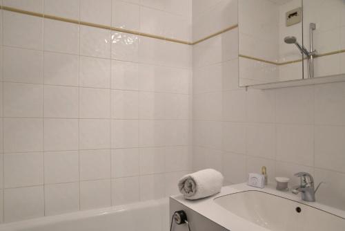 une salle de bain blanche avec une baignoire et un lavabo dans l'établissement Residence 3000 - Studio pour 4 Personnes 98, à Mâcot La Plagne