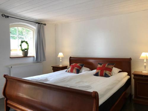 a bedroom with a bed with white sheets and pillows at Husargårdens Bed & Breakfast in Sjöbo