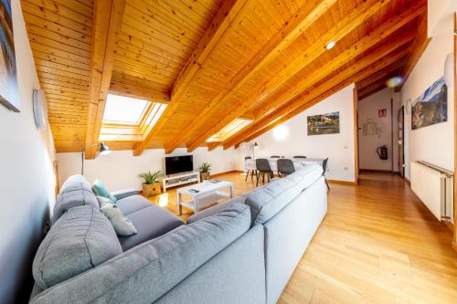 a large living room with a long couch and wooden ceilings at RENOVADO - Ático Plaza Herradores, céntrico y con Wifi in Soria