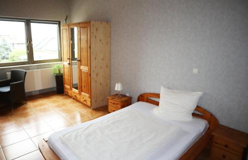a bedroom with a white bed and a window at Via Eberle - Vinothek und Gästezimmer in Grünstadt