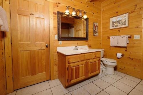 a bathroom with a sink and a toilet and a mirror at Mountain Serenity in Gatlinburg