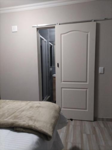 a bedroom with a door and a bed with a pillow at Willow's Guesthouse in Vereeniging