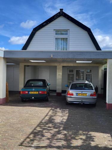 two cars parked in front of a house at vakantie appartement Stadskanaal in Stadskanaal