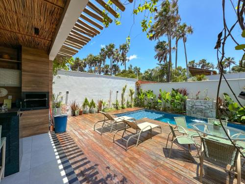 an outdoor patio with chairs and a swimming pool at Casa Reserva Boa Vista nos Lençóis 5 suítes in Barreirinhas