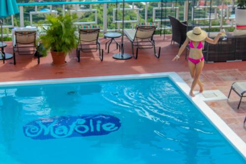 a woman in a bikini jumping into a swimming pool at The Mafolie Hotel in Mafolie