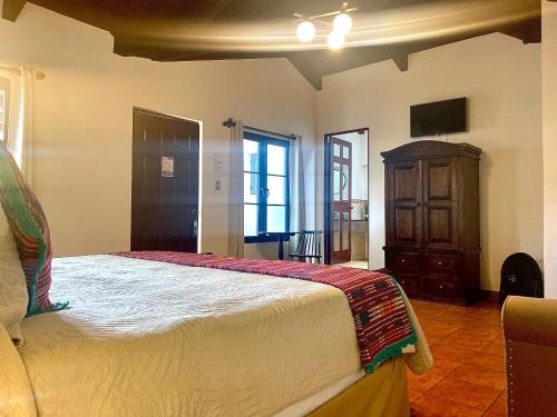 a bedroom with a bed and a tv in a room at Hotel la Galería in Antigua Guatemala