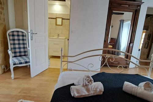 - une chambre avec un lit, des serviettes et un miroir dans l'établissement Havre de paix a Domme, à Domme