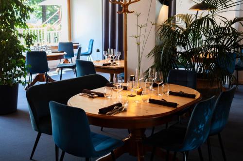 - une table dans un restaurant avec des chaises et des verres à vin dans l'établissement Hotel Restaurant Les Glycines, à Vieille-Brioude