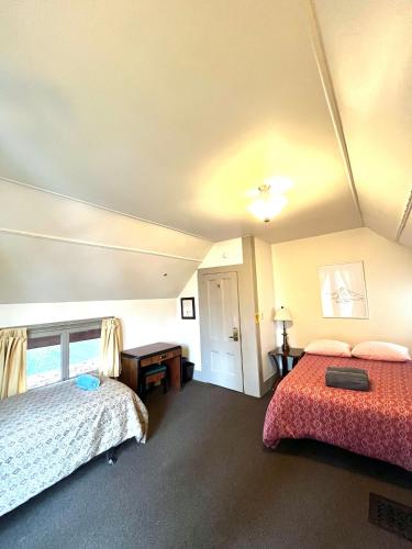 a hotel room with two beds and a table at Northwest Portland Hostel in Portland