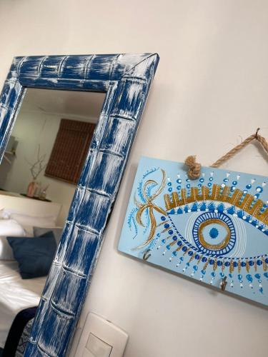 a mirror on a wall with a picture of an eye at Capim Limão Containers do Rosa in Praia do Rosa