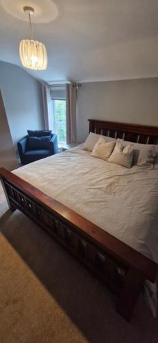 a large bed with a wooden frame in a bedroom at The willow tree inn in Pilsley