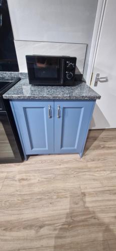 a blue cabinet with a microwave on top of it at The willow tree inn in Pilsley