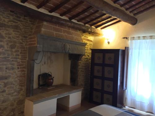a bedroom with a fireplace in a brick wall at Locanda Petrella in Cortona